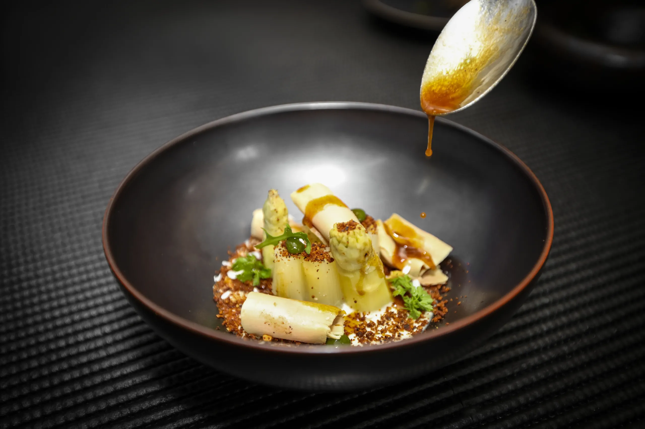 Plat d'asperges avec sauce et garniture.