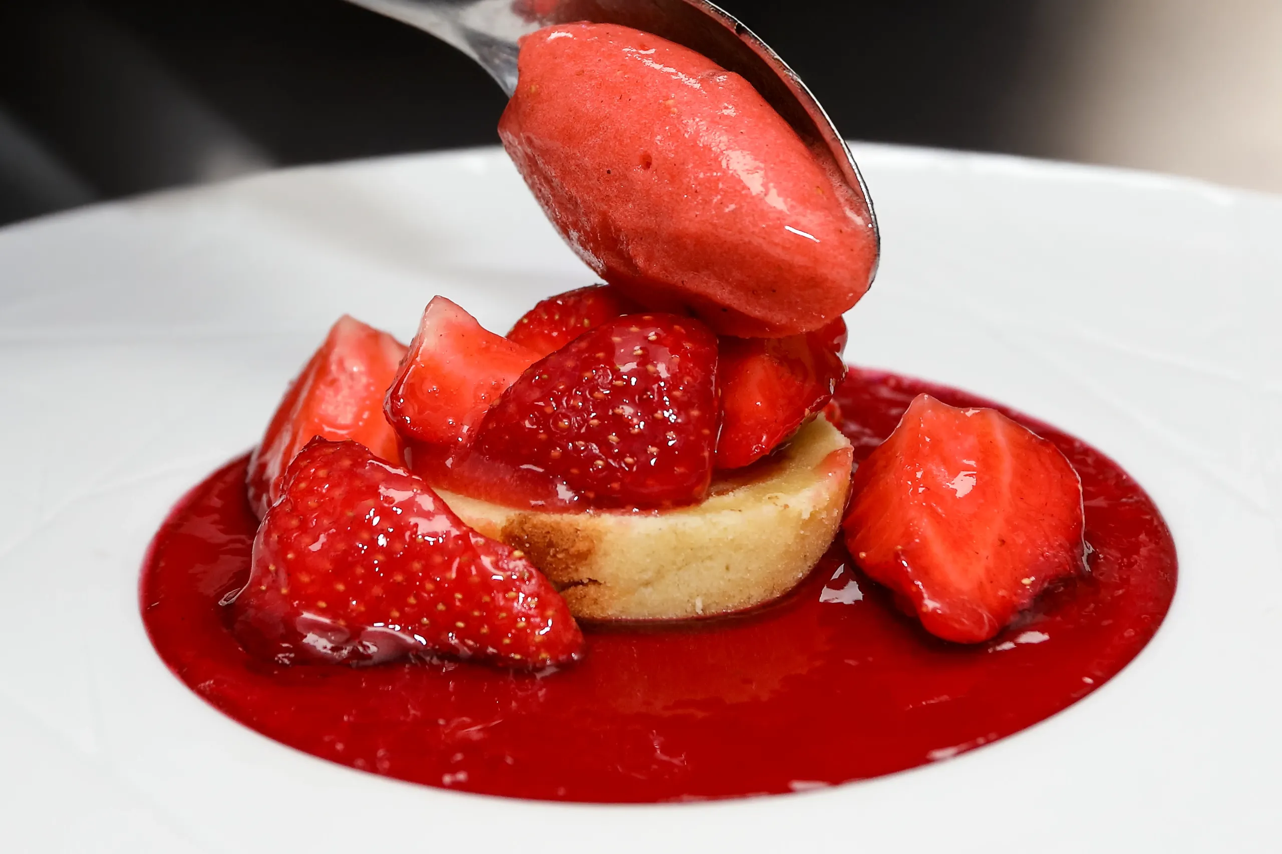 Dessert aux fraises nappé de coulis rouge.