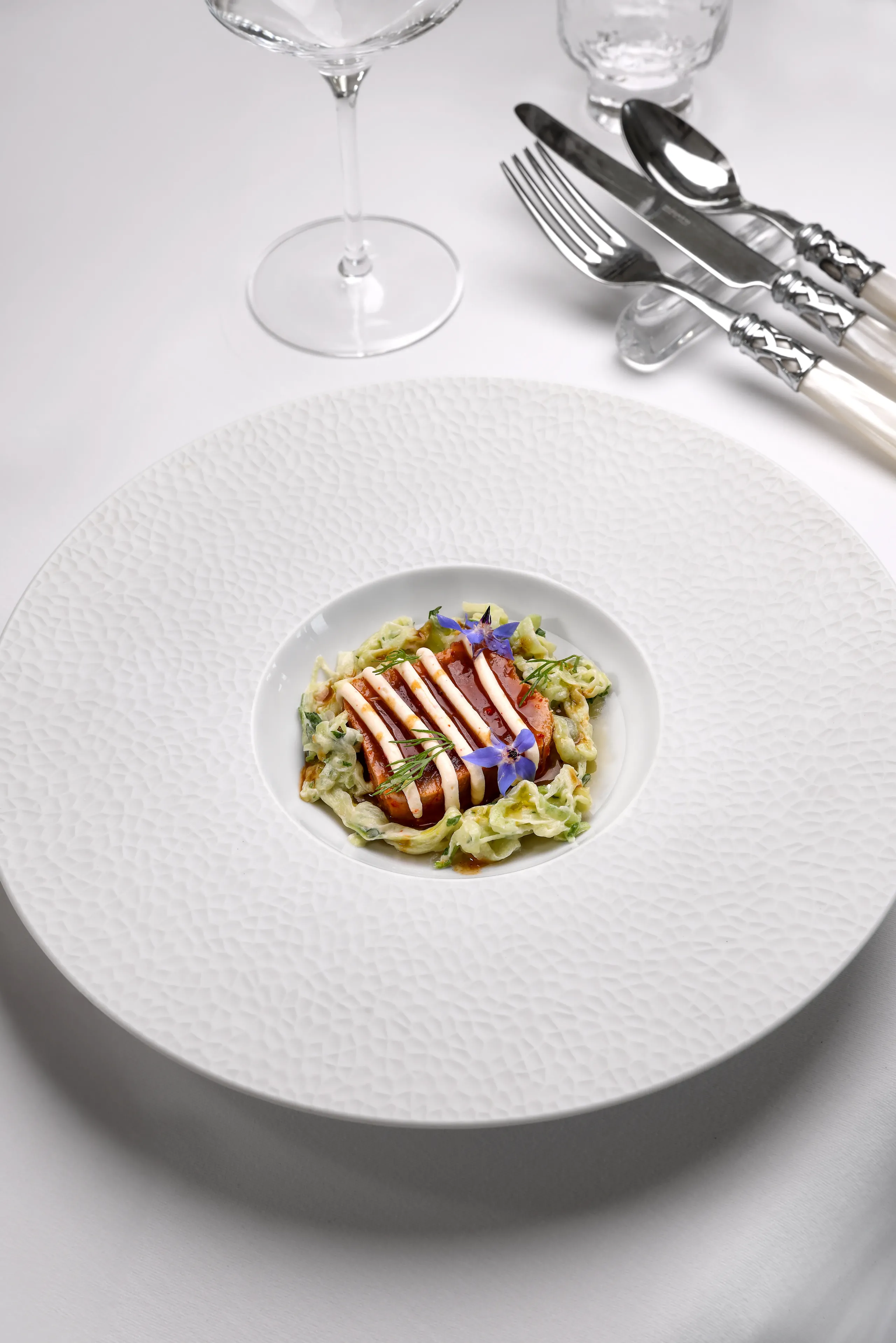 Plat gastronomique décoré avec des fleurs comestibles.