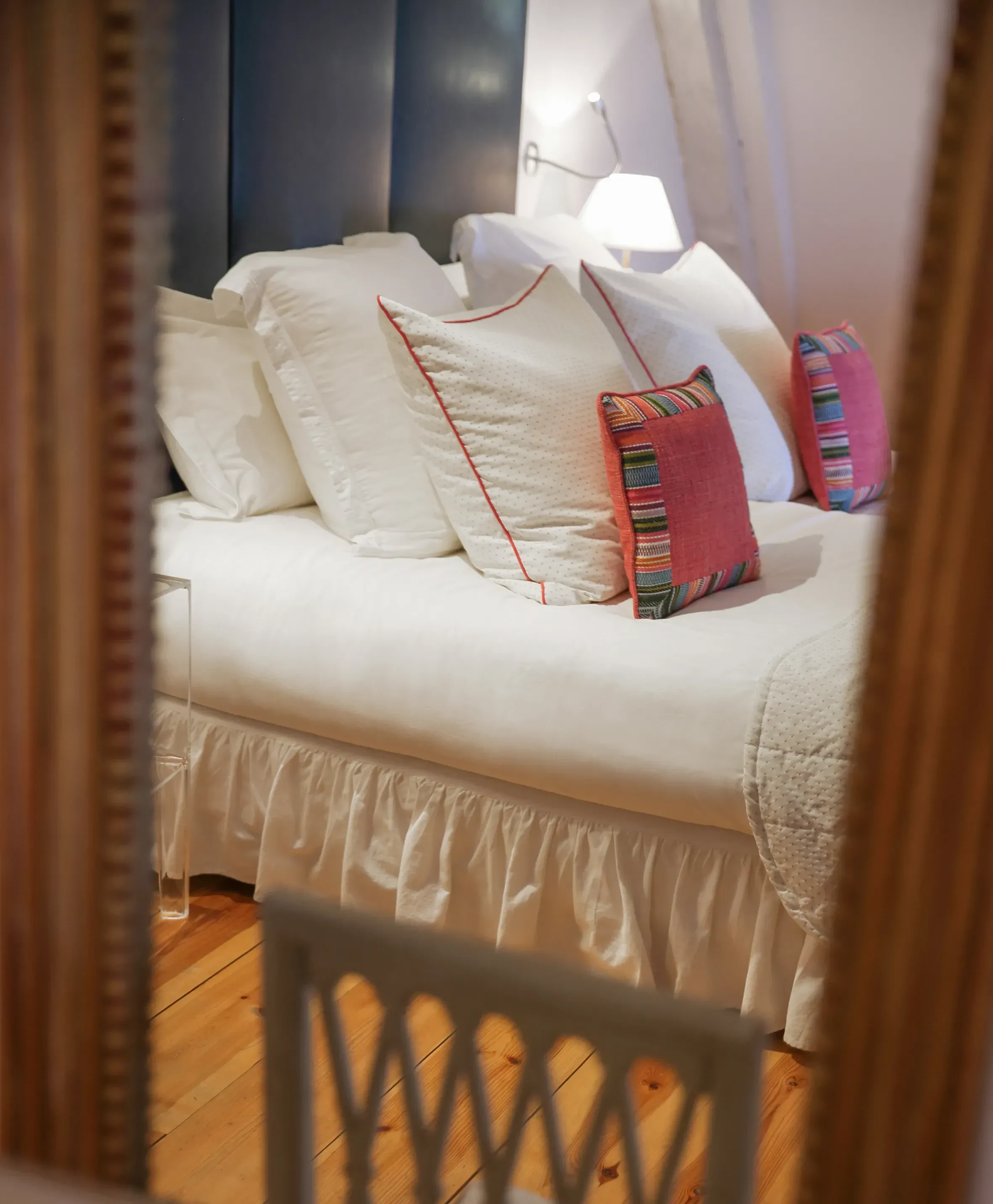 Lit avec coussins colorés et lampe.