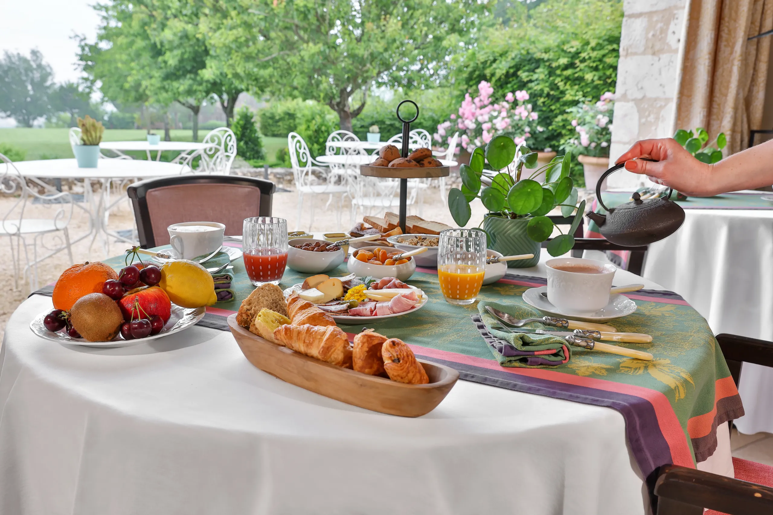 Petit-déjeuner varié en terrasse jardin verdoyant