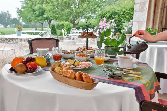 Petit-déjeuner varié en terrasse jardin verdoyant