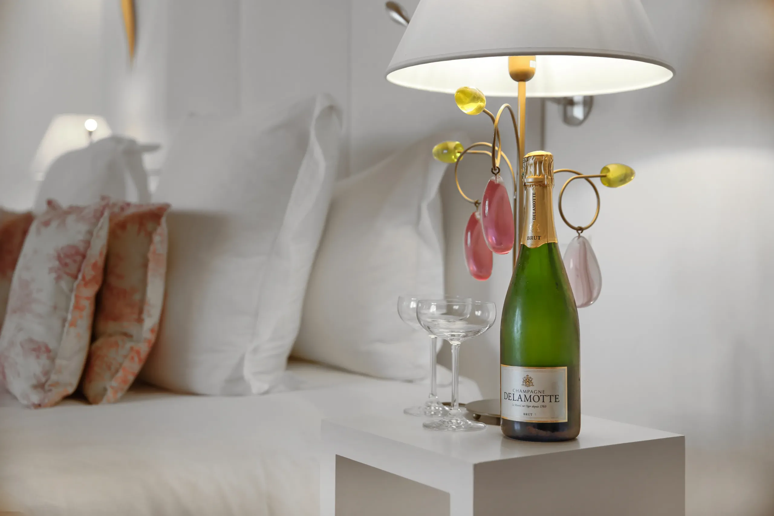Chambre luxueuse avec champagne et verres sur table.