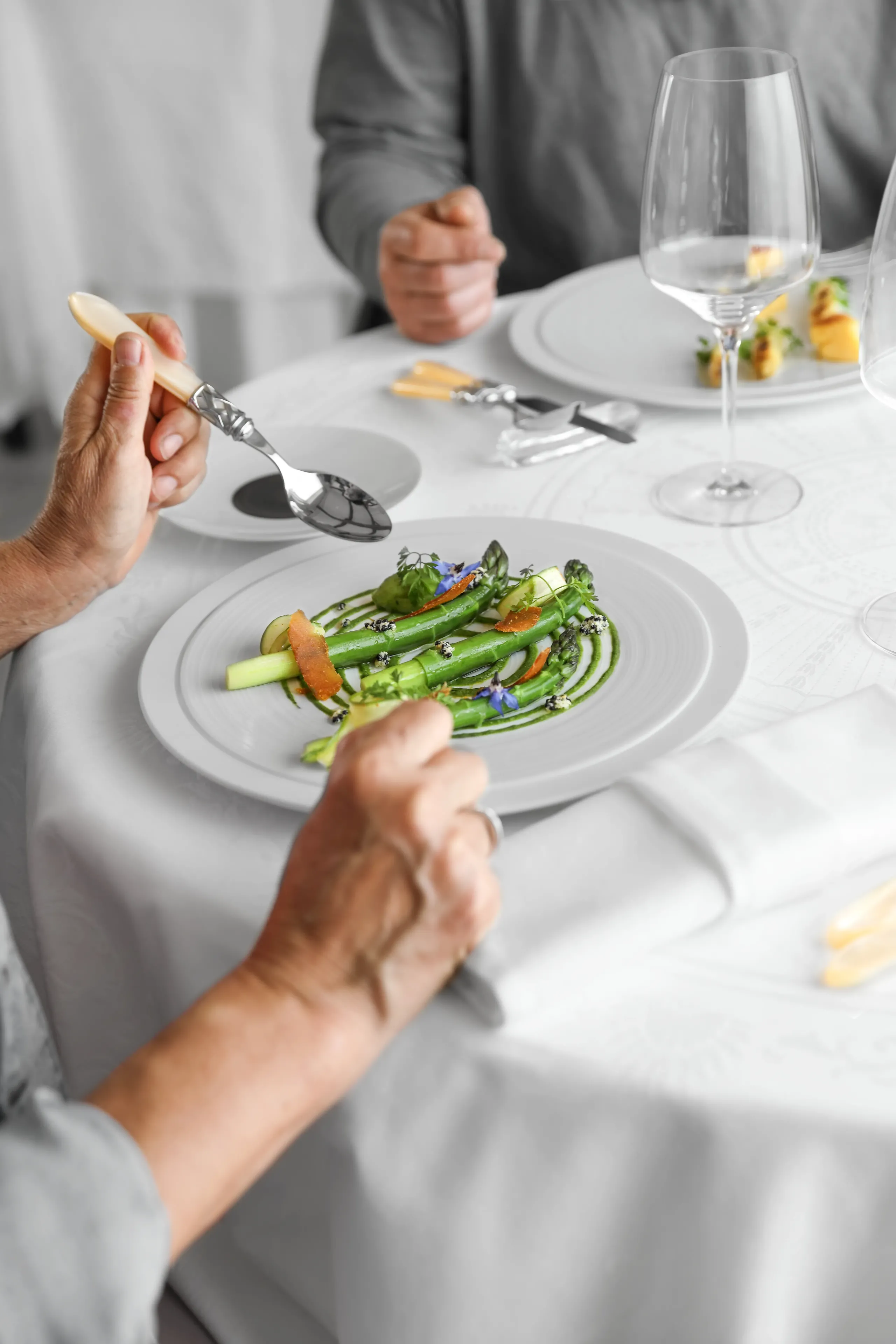 Plat gastronomique avec asperges sur table élégante.