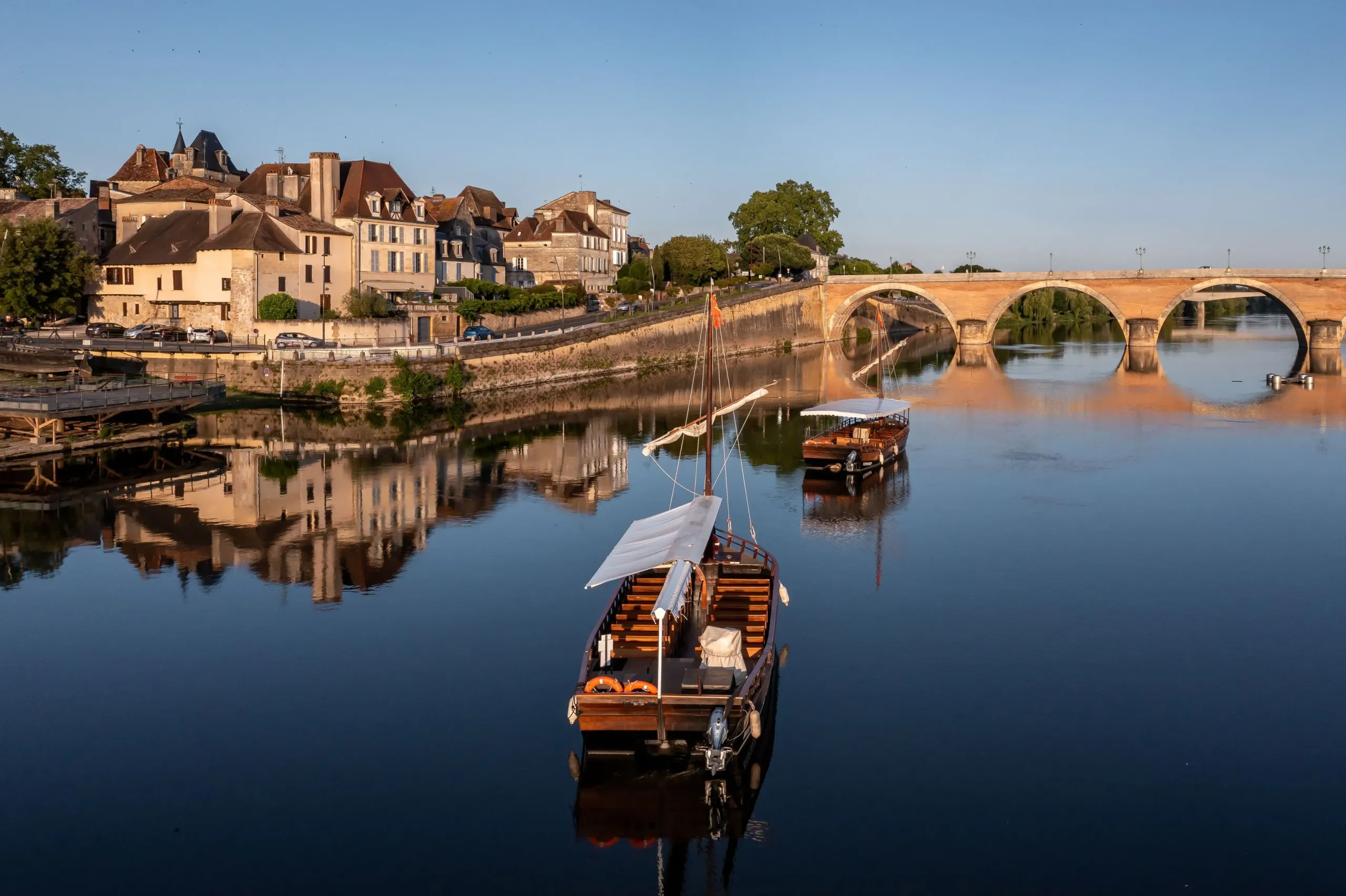 Bateaux sur rivière avec pont en arrière-plan.