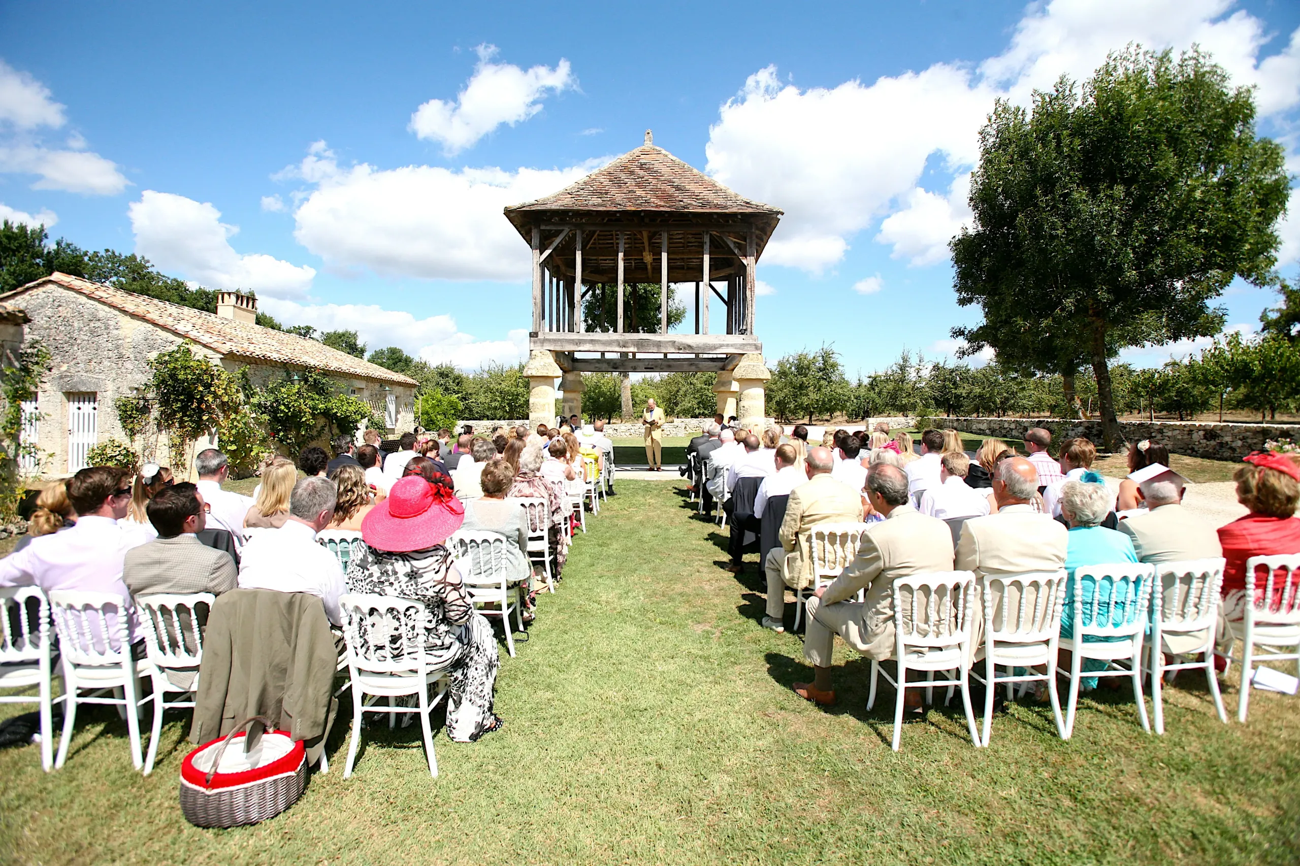 Cérémonie de mariage en plein air, invités assis.