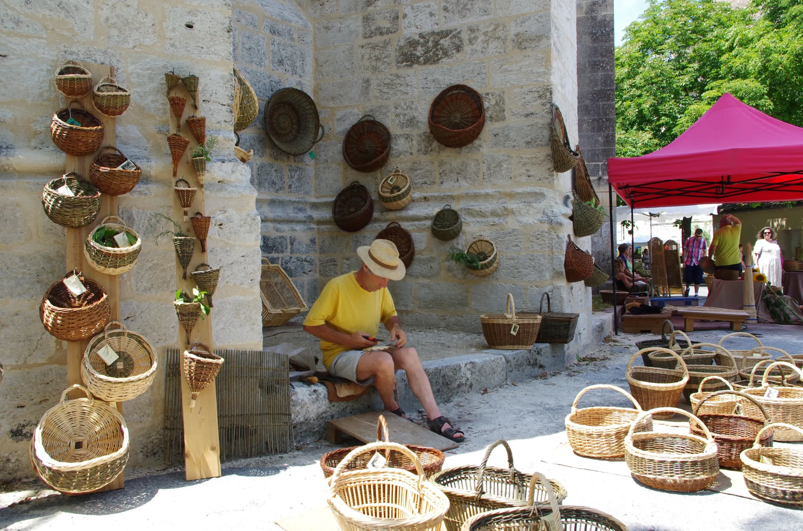 Homme assis, fabriquant des paniers en osier.