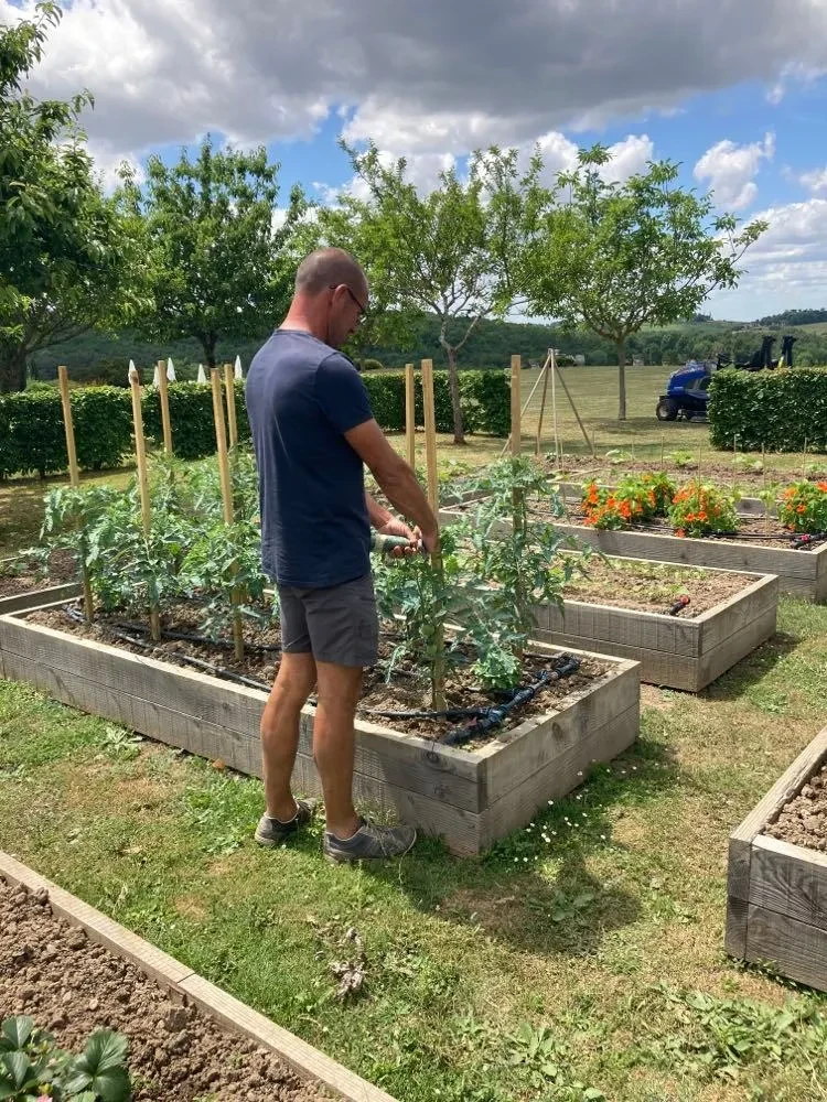 Homme jardinant avec des plates-bandes surélevées.