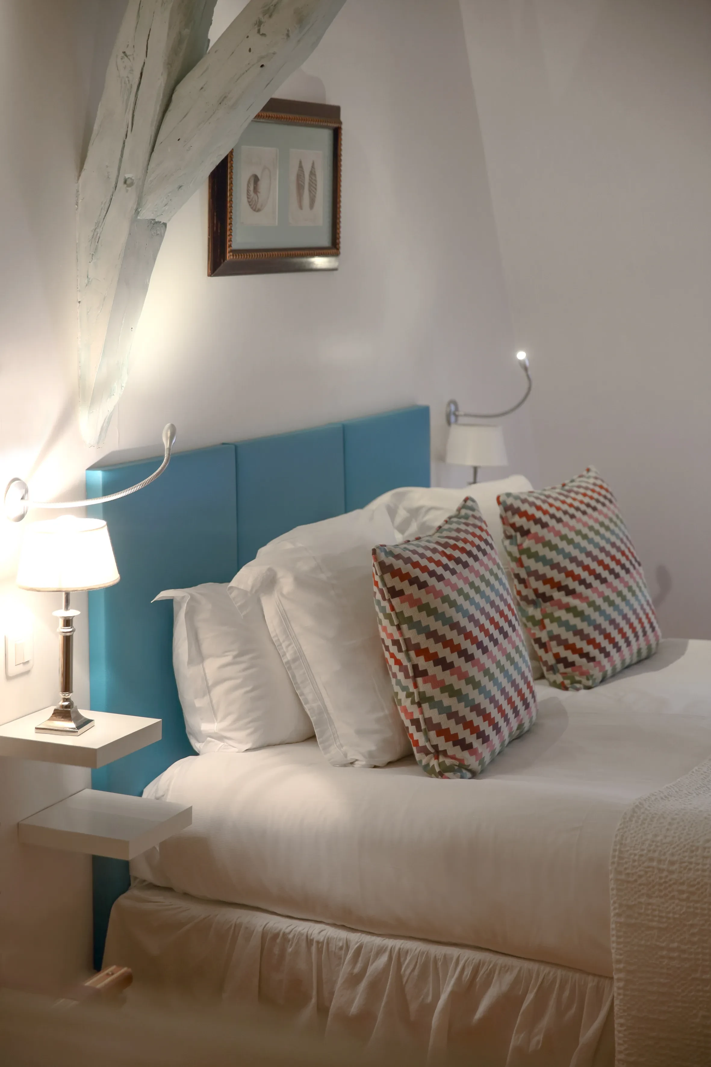 Chambre confortable avec lit et coussins colorés.