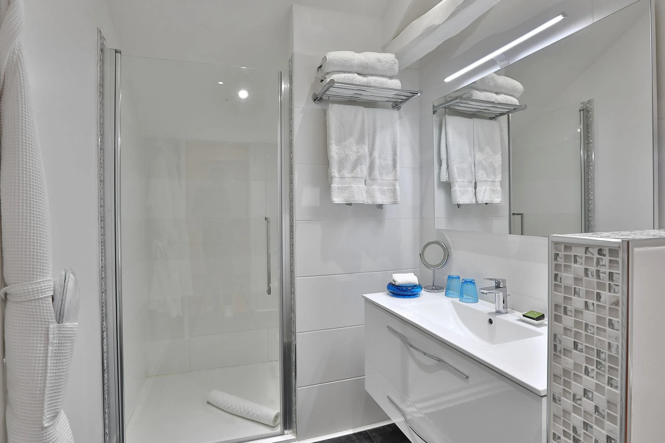 Salle de bains moderne avec douche et lavabo.