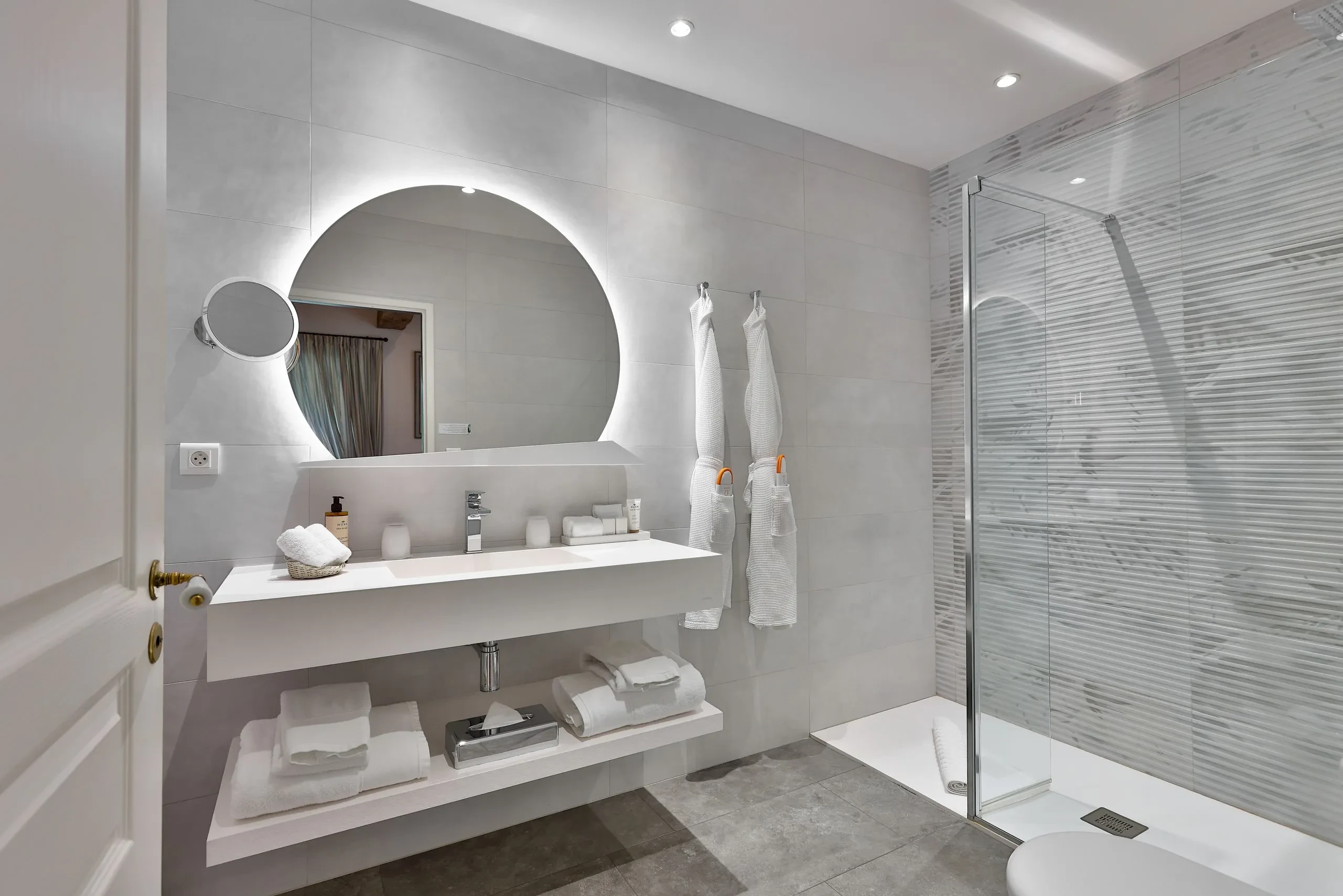 Salle de bain moderne avec douche et lavabo.