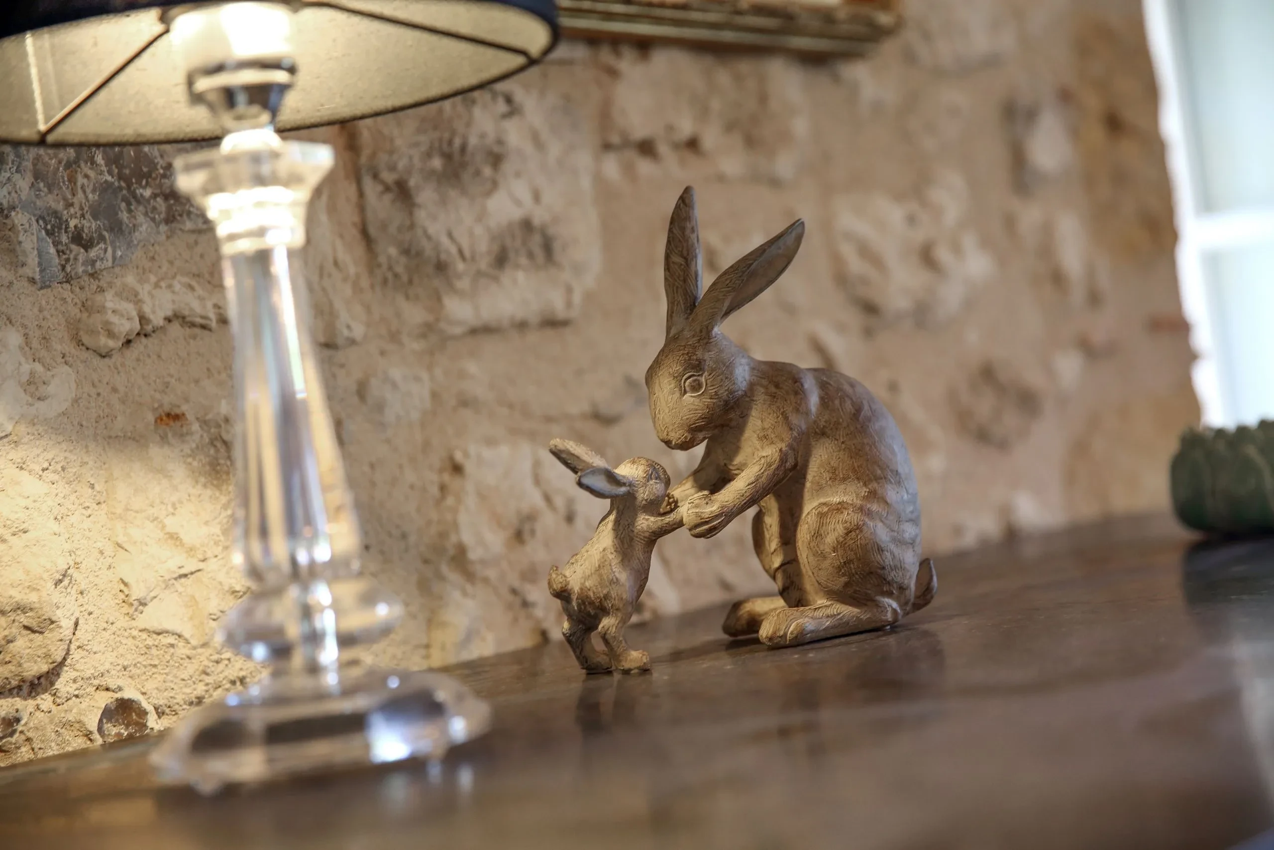 Sculptures de lapins en bois sous une lampe.