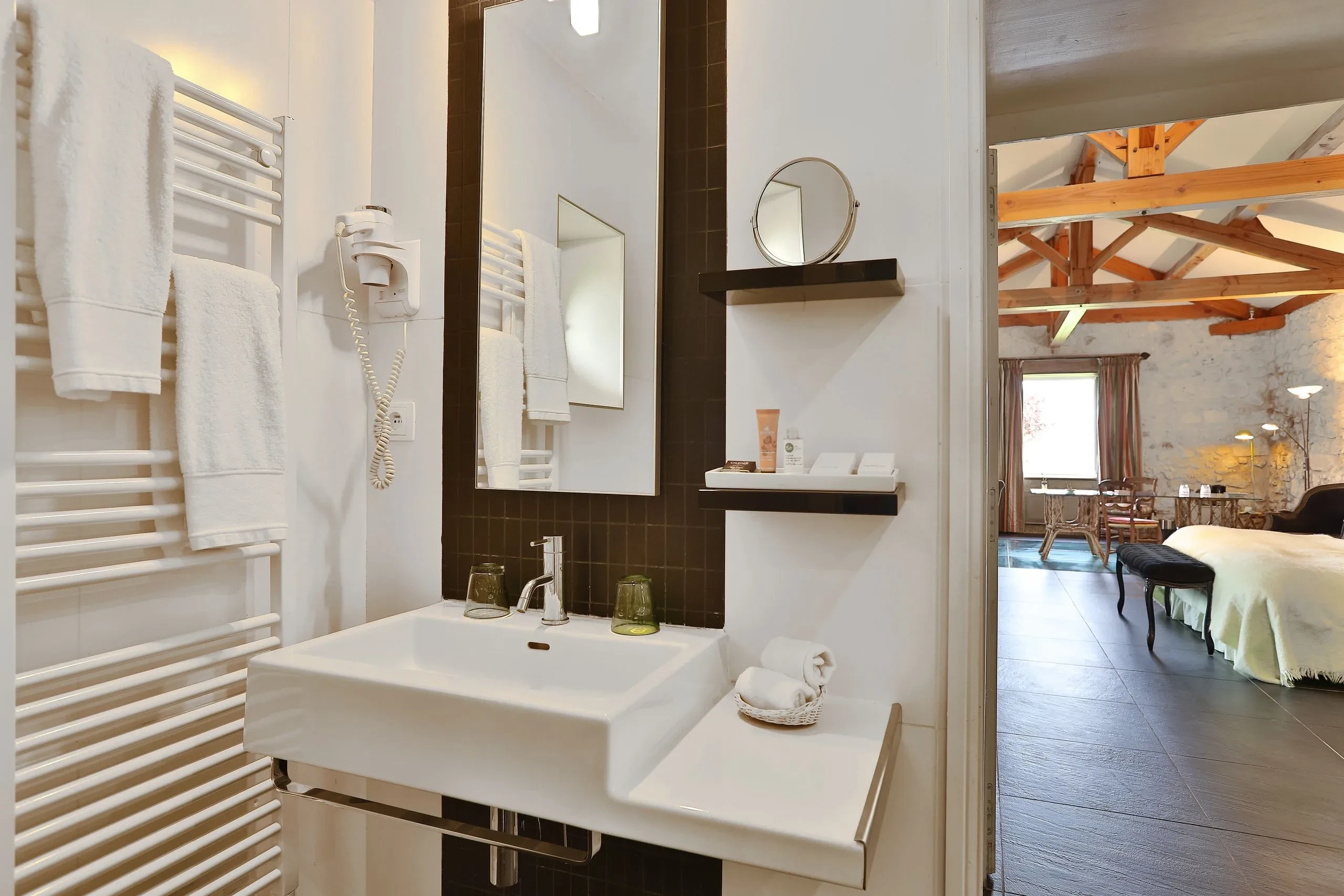 Salle de bain moderne avec lavabo et chambre adjacente.