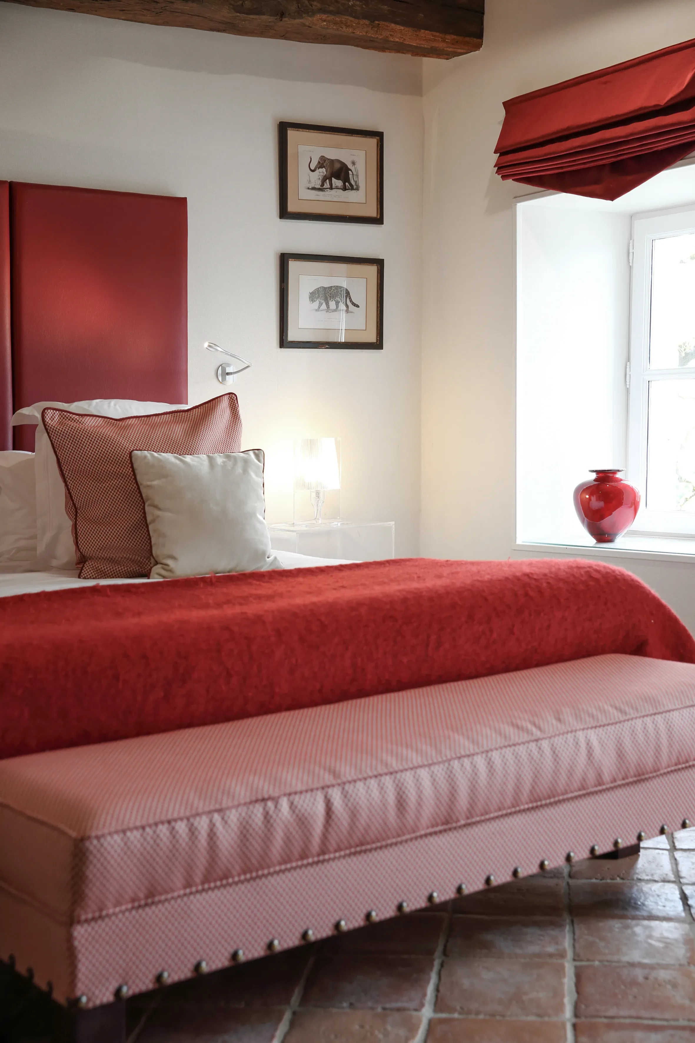 Chambre élégante avec literie rouge et décoration artistique.