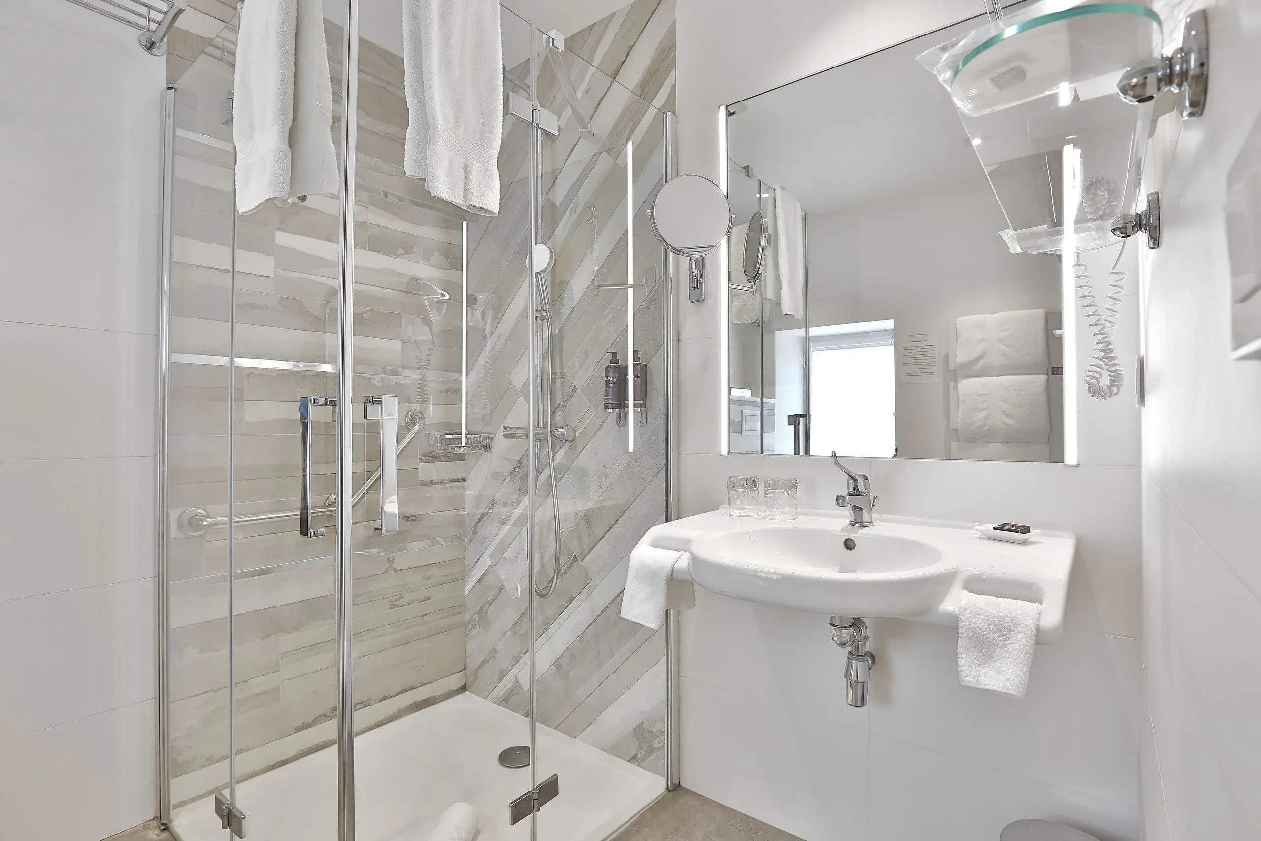 Salle de bain moderne avec douche vitrée.