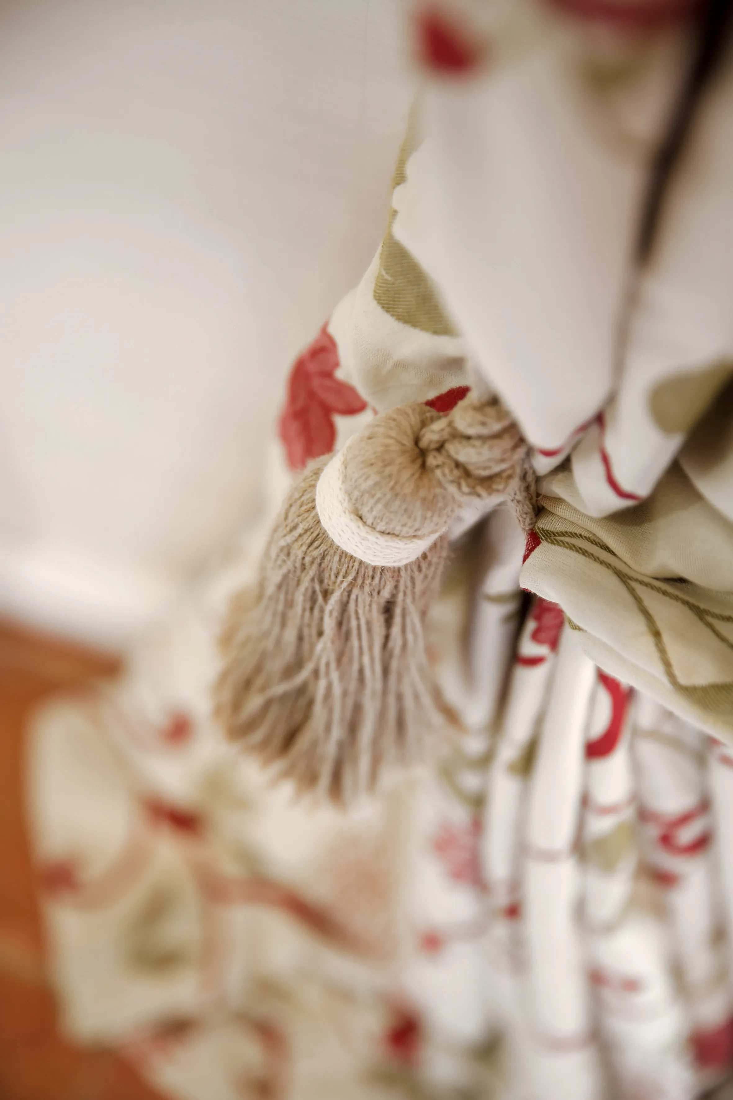 Gland beige et rideau à motifs floraux.