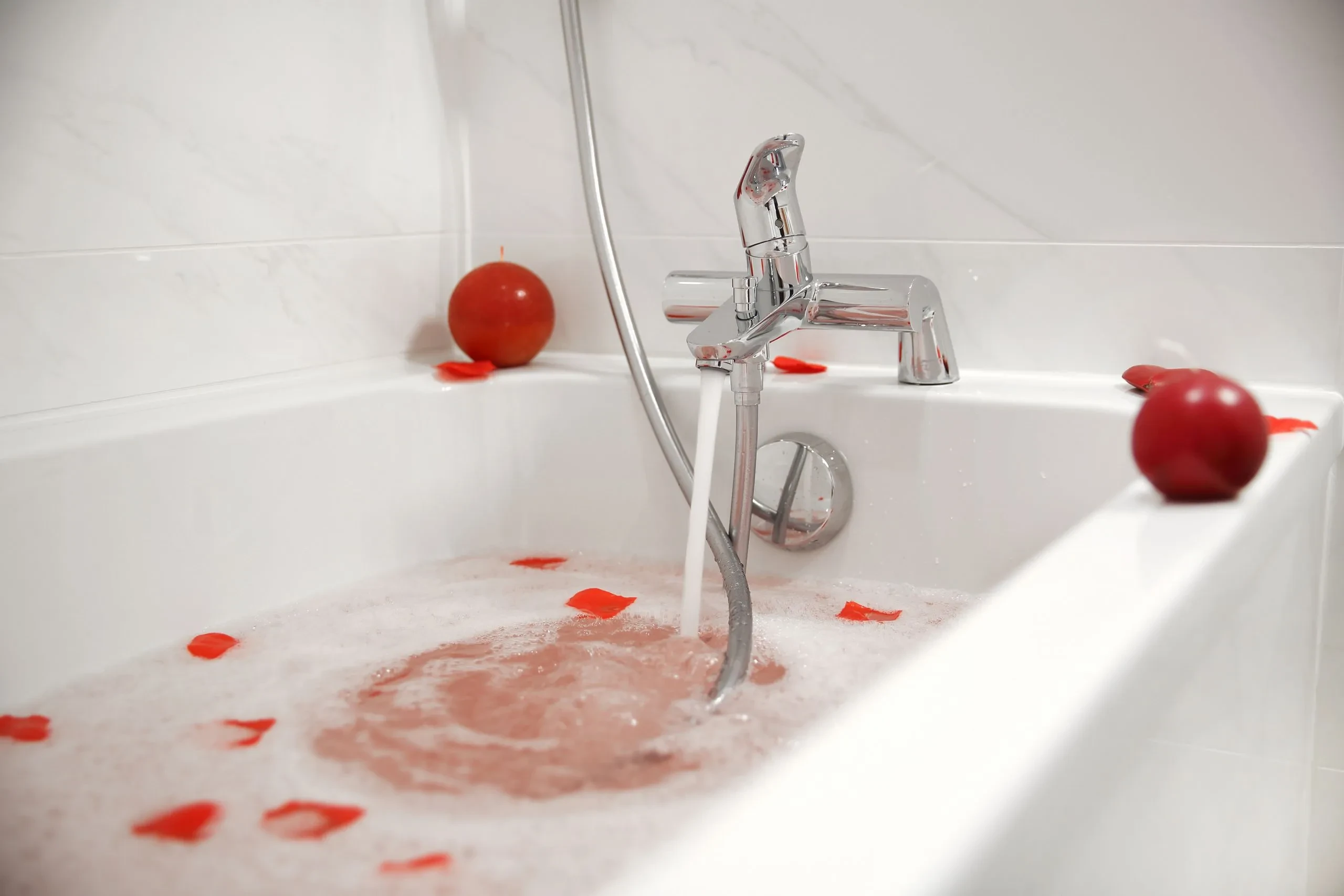 Bain moussant avec pétales rouges et boules.
