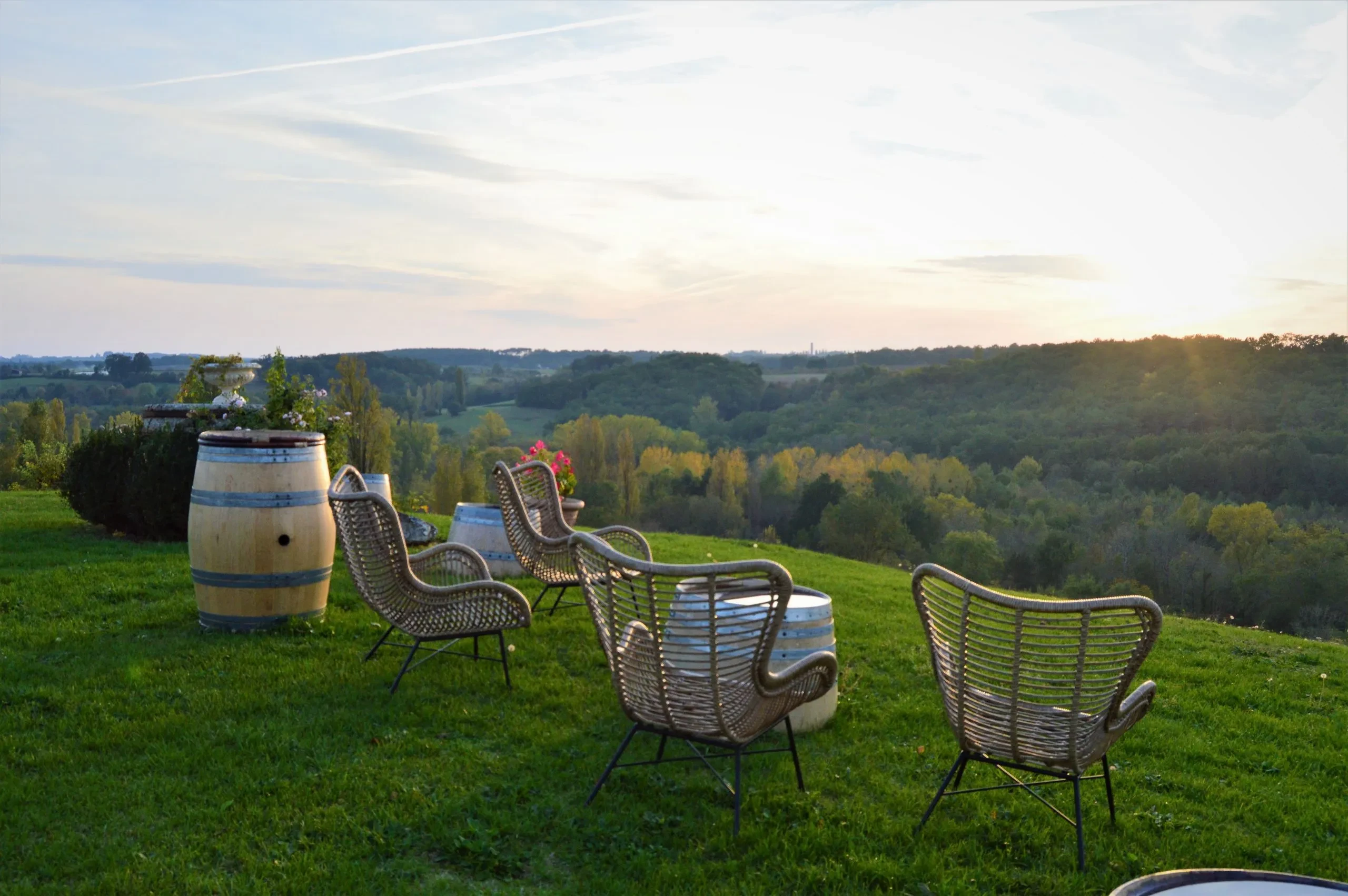 Terrasse avec vue sur collines verdoyantes au coucher du soleil.