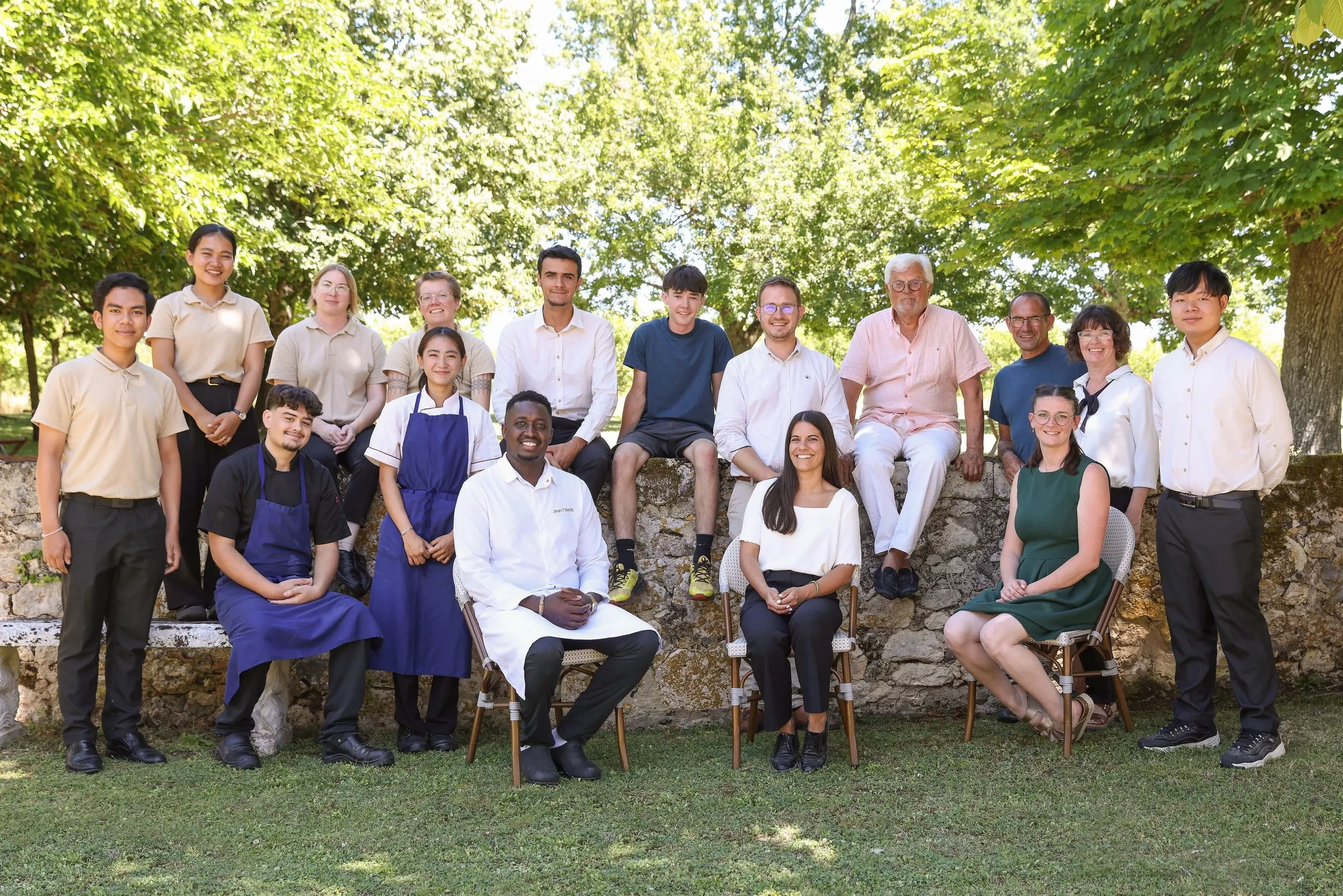 Équipe posant ensemble dans un jardin ensoleillé.