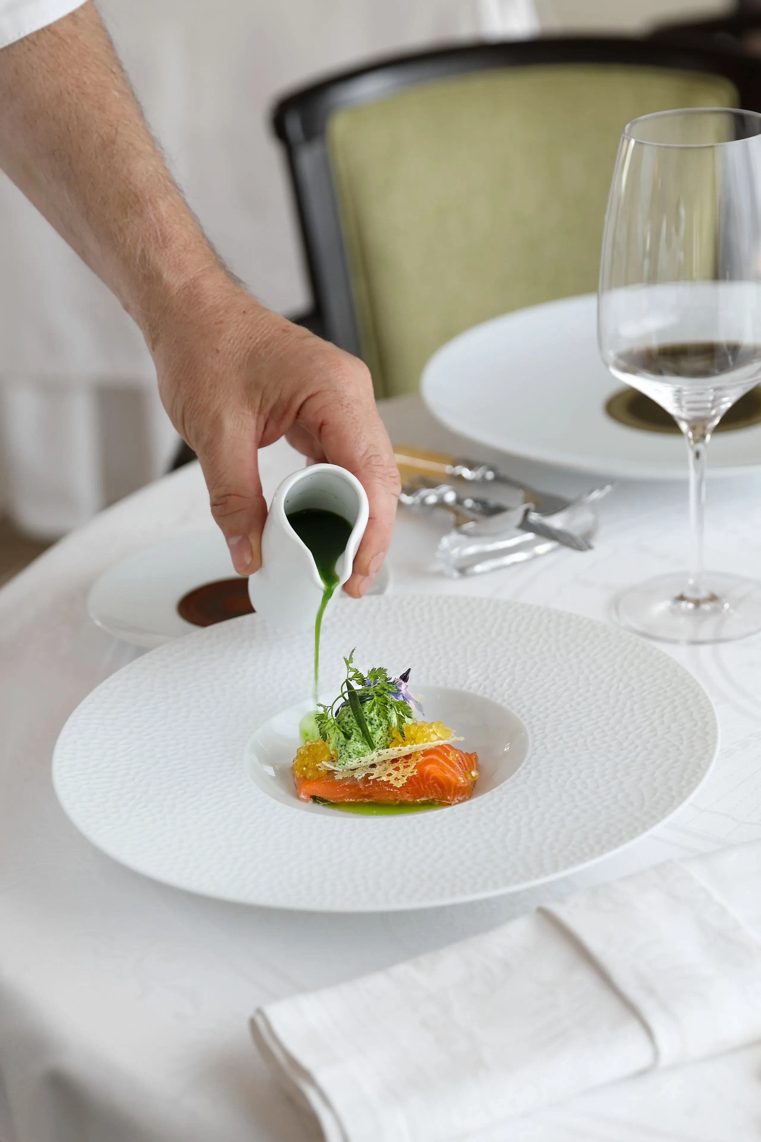 Versement de sauce sur un plat gastronomique élégant.