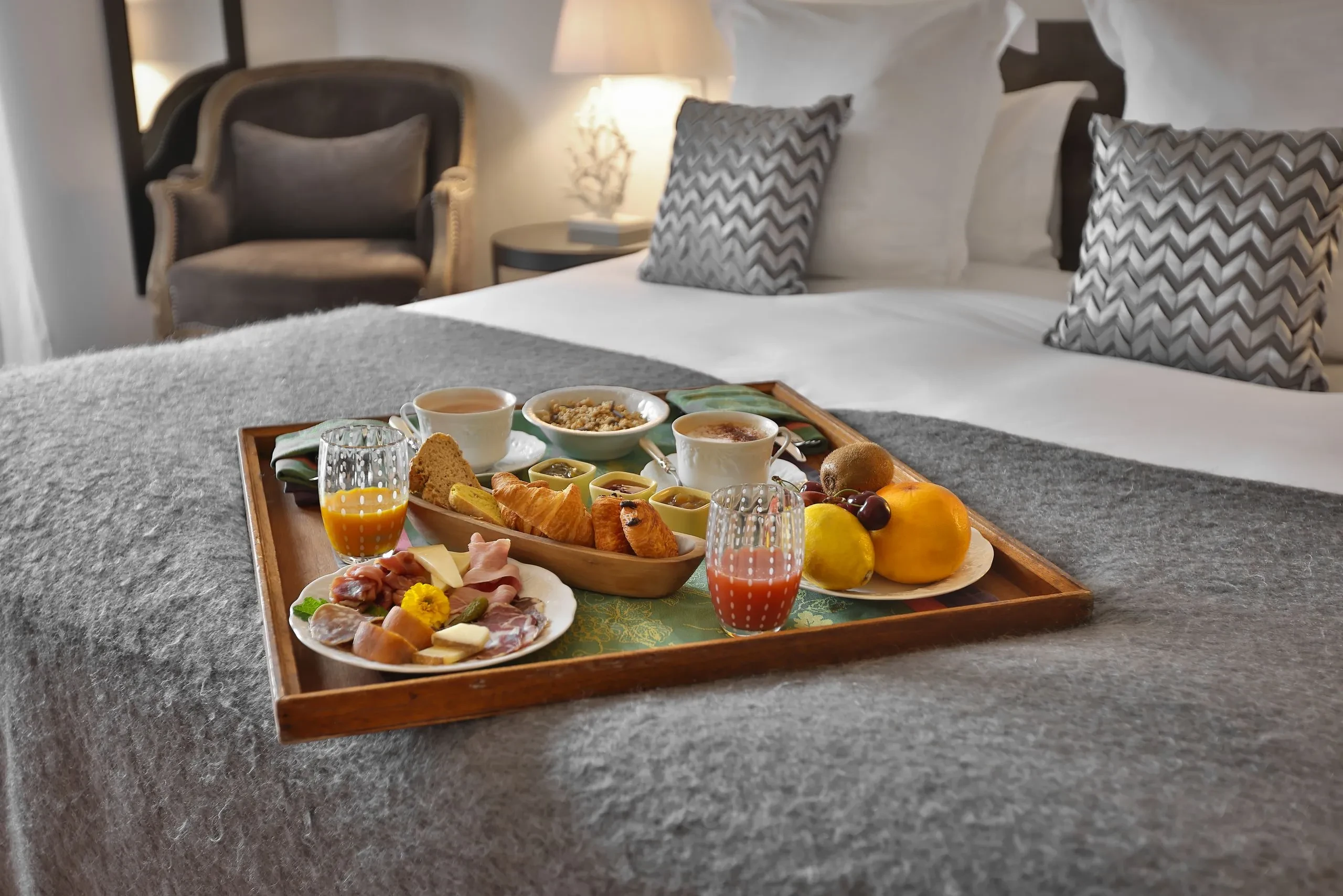 Petit déjeuner sur lit, croissants et jus d'orange.