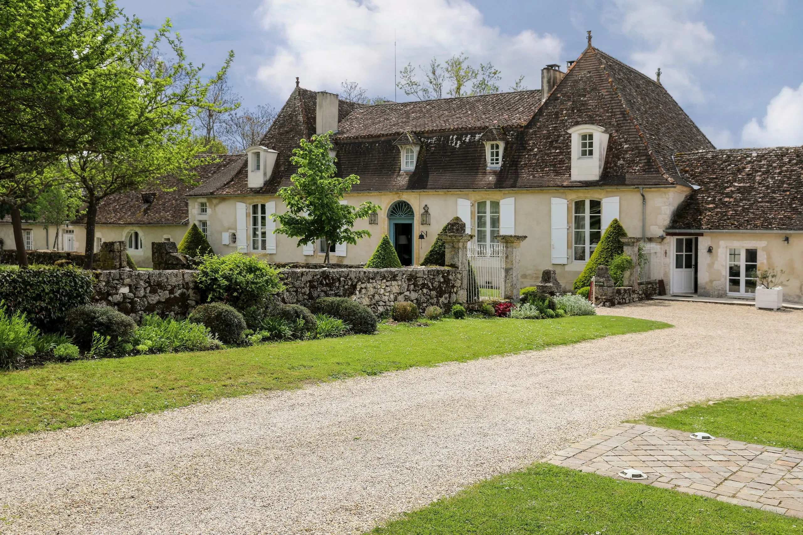 Maison de campagne avec jardin verdoyant.