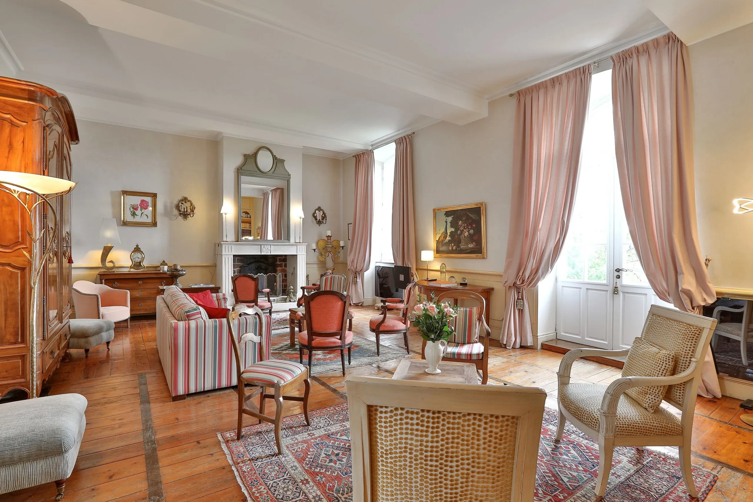 Salon élégant avec meubles anciens et cheminée.