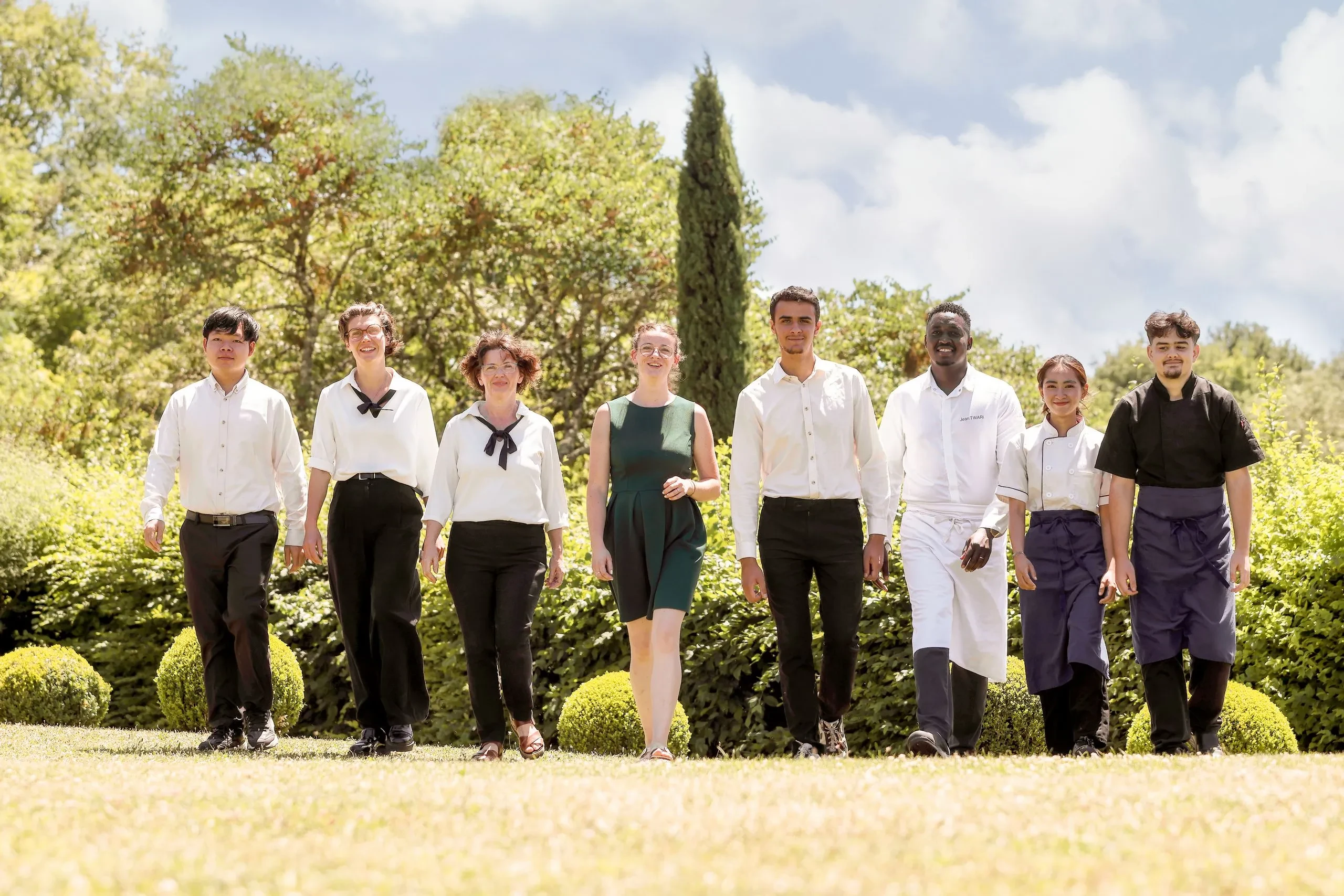Groupe de personnes souriantes en extérieur.