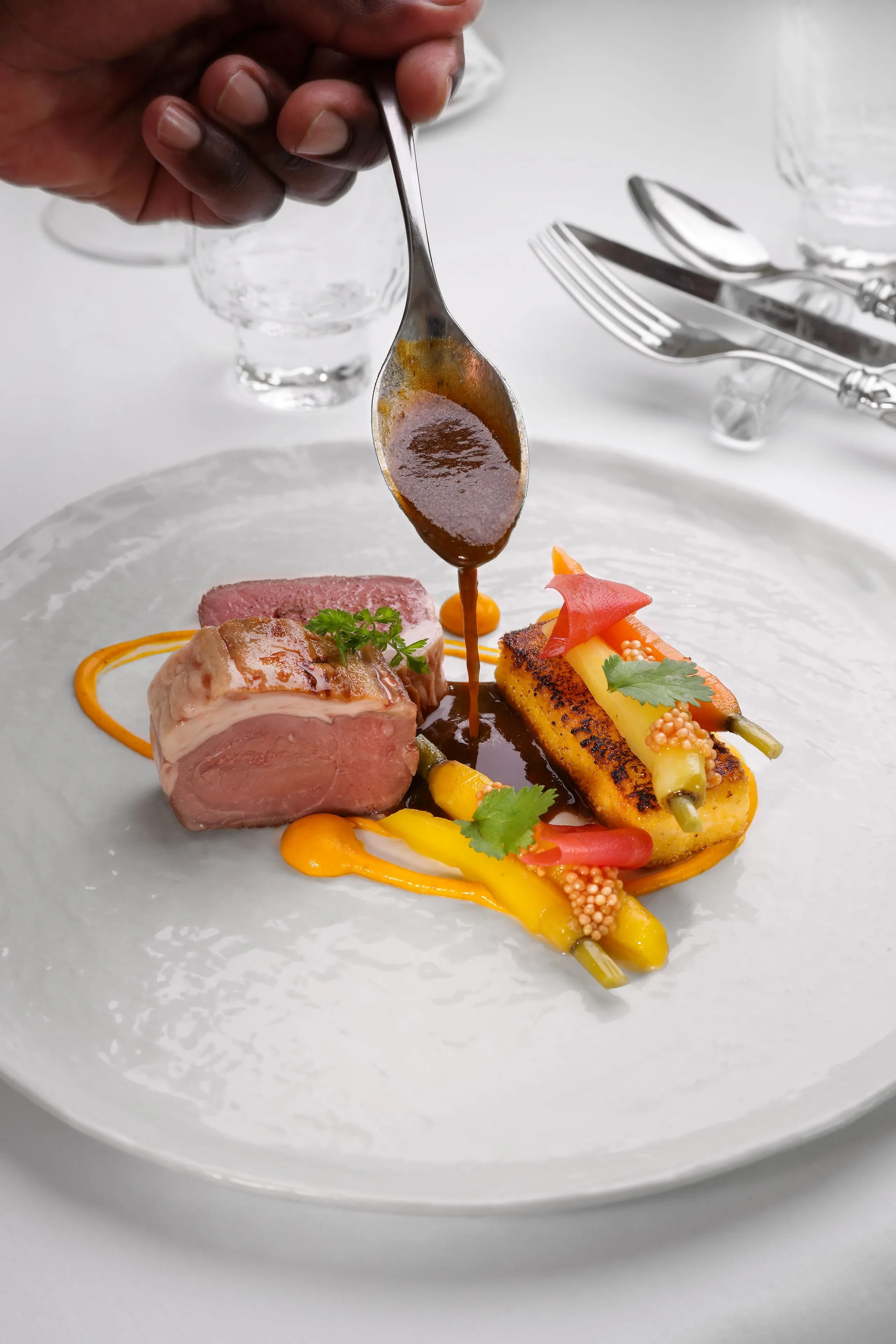 Plat gastronomique avec viande et légumes colorés.