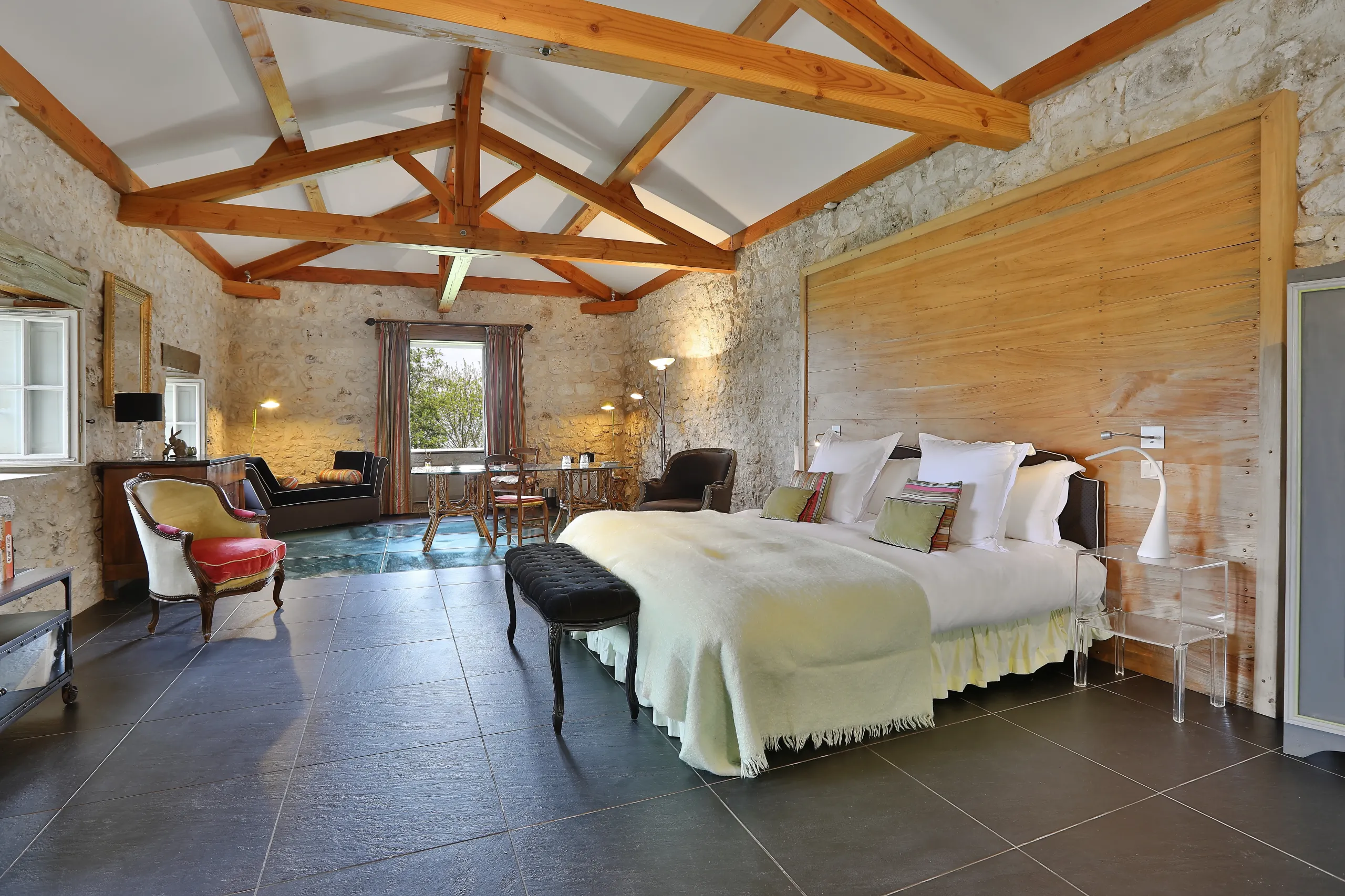 Chambre spacieuse avec lit double et poutres apparentes.