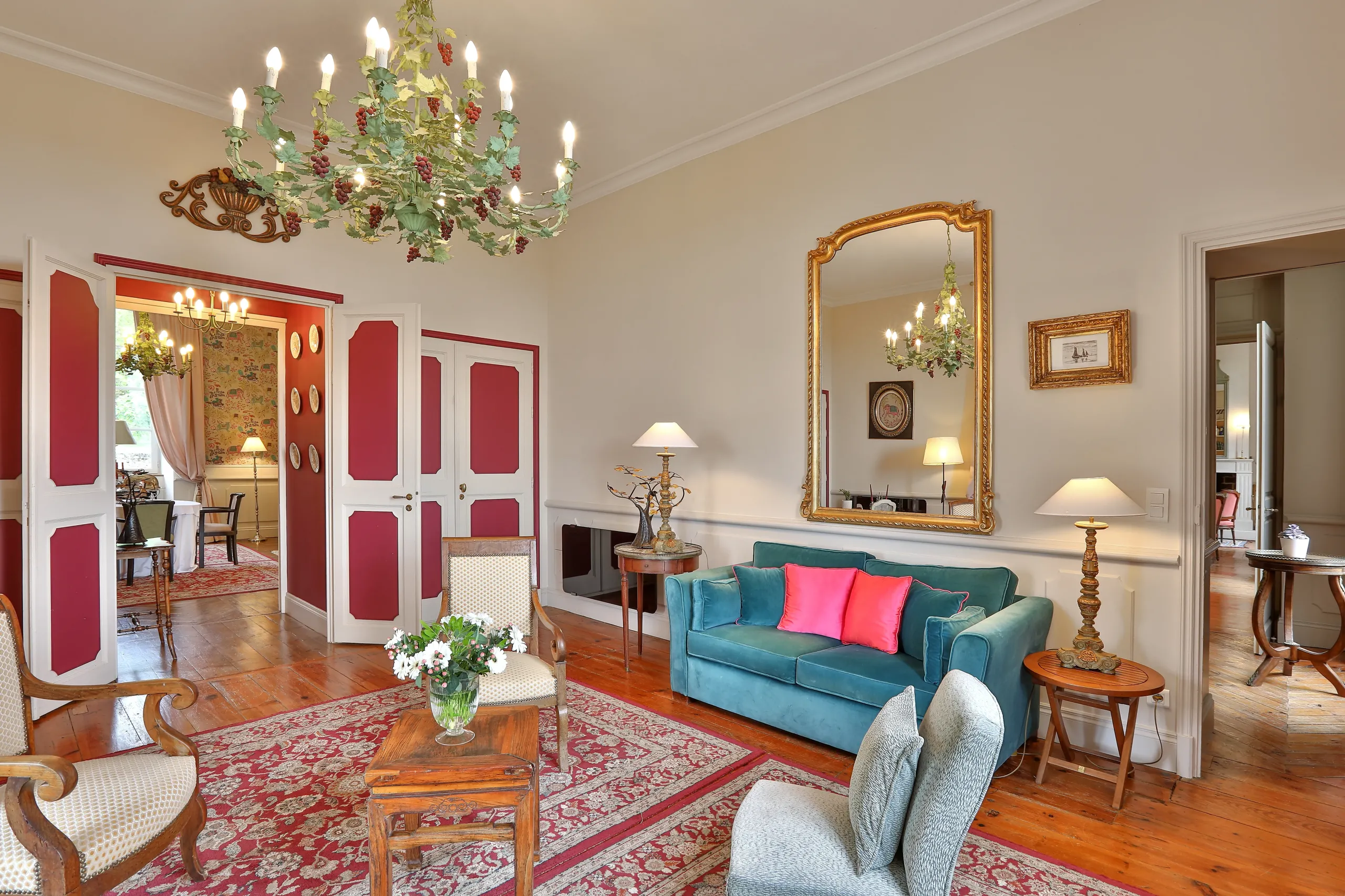 Salon élégant avec canapé bleu et lustre luxuriant.