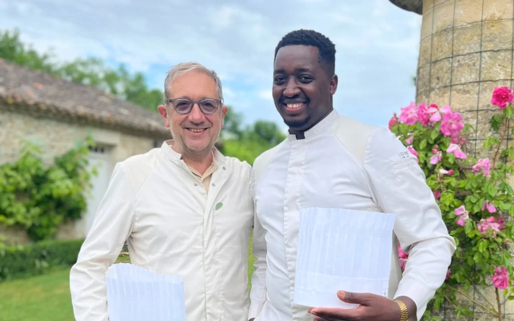 Deux chefs en veste blanche souriants.