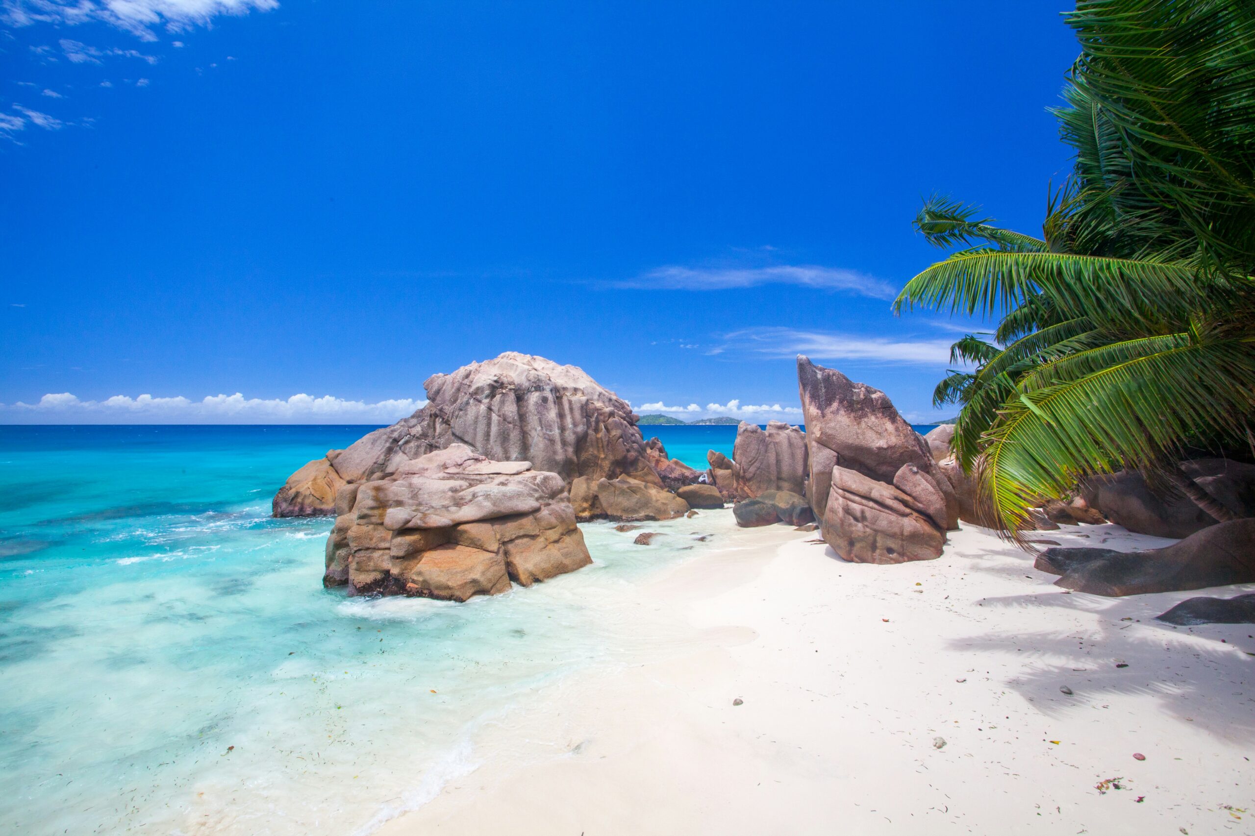 Plage tropicale avec rochers et mer turquoise.